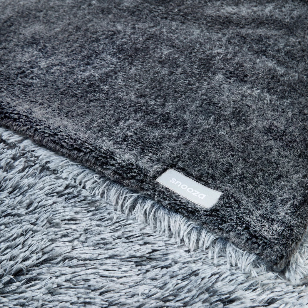 Gray textured Snooza blanket with the Snooza brand label on a matching gray background