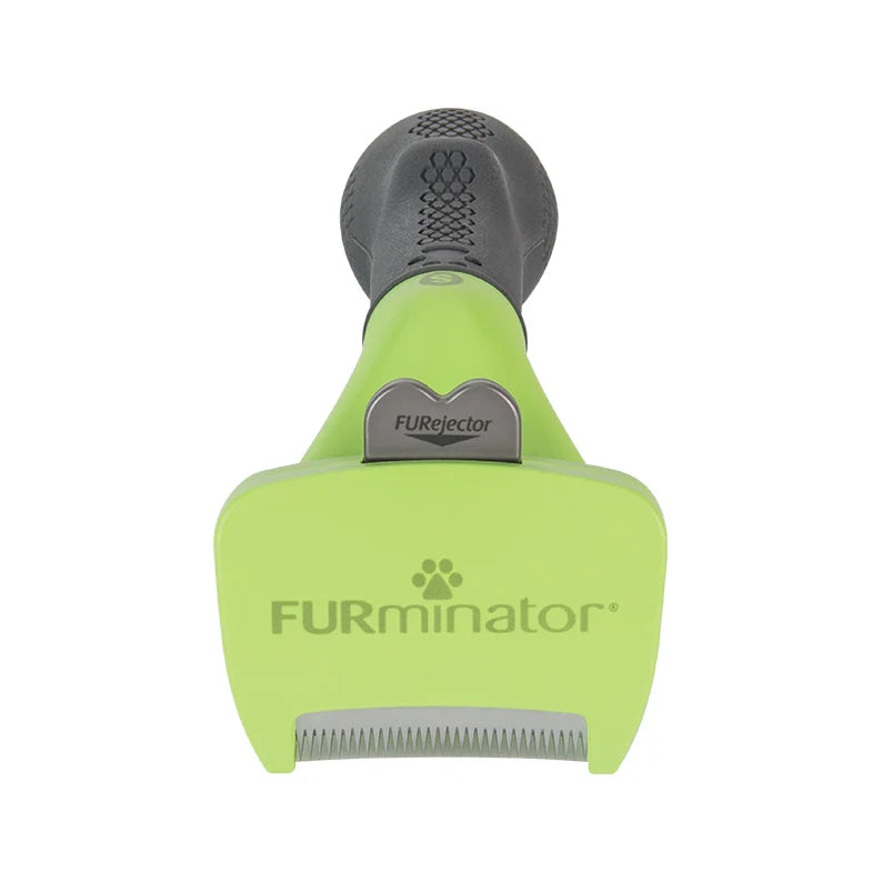 Green and gray FURminator pet grooming tool on a white background